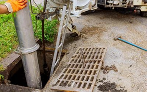 Photo of sanitation worker pumping sewage